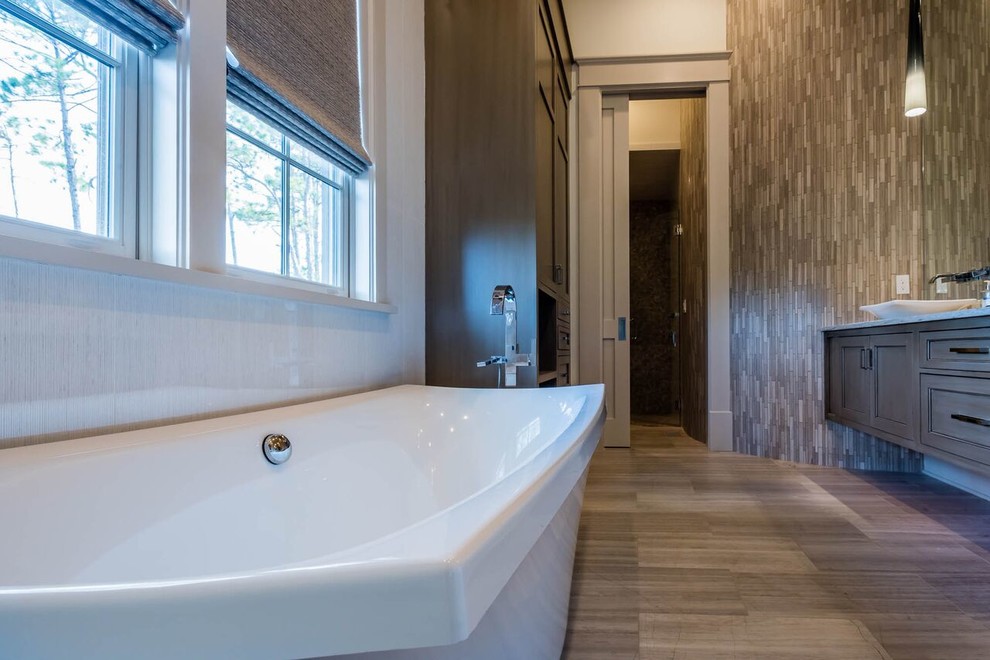 Exemple d'une salle de bain principale tendance en bois foncé de taille moyenne avec un placard à porte affleurante, une baignoire indépendante, une douche à l'italienne, WC à poser, un carrelage beige, un carrelage de pierre, un mur beige, parquet foncé, une vasque et un plan de toilette en stratifié.