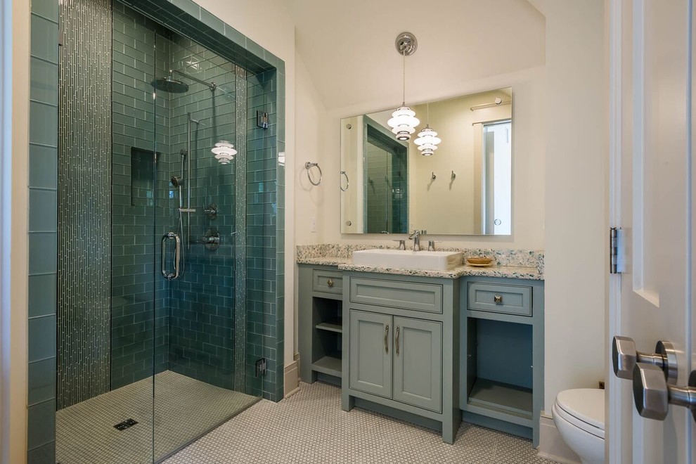 Exemple d'une salle d'eau chic de taille moyenne avec un placard à porte affleurante, des portes de placard bleues, une baignoire indépendante, une douche à l'italienne, WC à poser, un carrelage bleu, un carrelage en pâte de verre, un mur beige, parquet foncé, une vasque et un plan de toilette en stratifié.