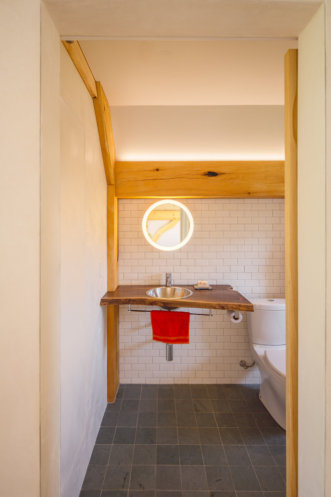 Idéer för små rustika brunt en-suite badrum, med en toalettstol med separat cisternkåpa, vit kakel, porslinskakel, vita väggar, ett nedsänkt handfat, träbänkskiva och grått golv