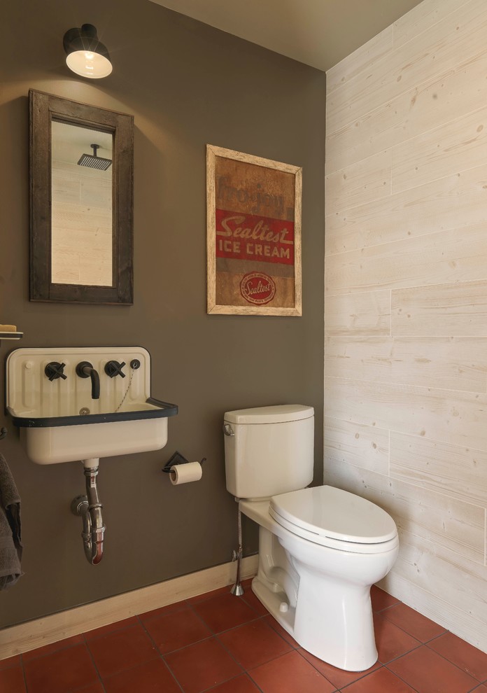 Idee per un bagno di servizio rustico con pareti verdi, pavimento in terracotta, lavabo sospeso e pavimento marrone