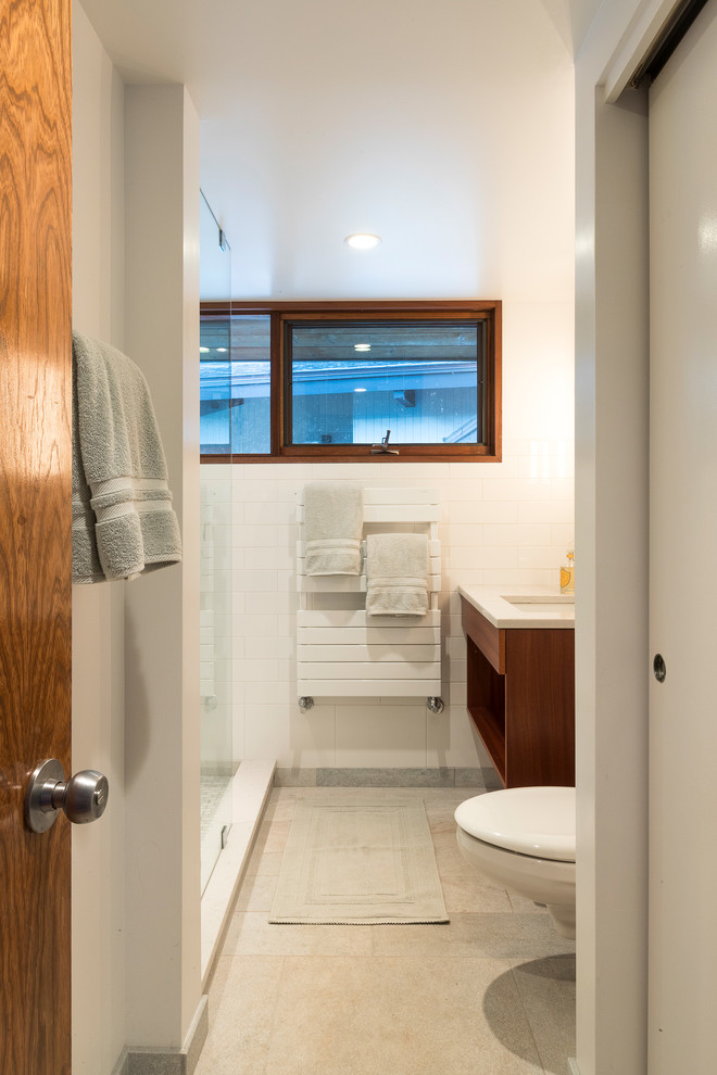 Design ideas for a small modern ensuite bathroom in Boston with open cabinets, medium wood cabinets, a walk-in shower, a wall mounted toilet, white tiles, ceramic tiles, white walls, marble flooring, a submerged sink and engineered stone worktops.