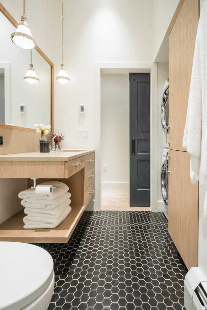 Bild på ett funkis badrum med dusch, med släta luckor, skåp i ljust trä, vita väggar, mosaikgolv, ett undermonterad handfat och svart golv