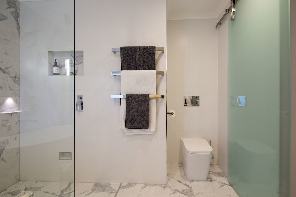 Example of a mid-sized minimalist master white tile and porcelain tile porcelain tile bathroom design in Melbourne with a wall-mount toilet and white walls