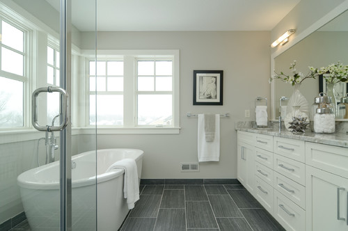 Bathroom cabinets with granite countertops in Classic Whites and Light Neutrals featuring a freestanding bathtub and large windows