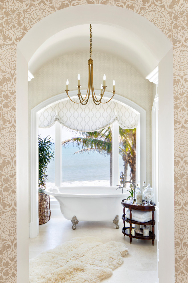 This is an example of a coastal bathroom in Philadelphia with a claw-foot bath, beige walls and beige floors.