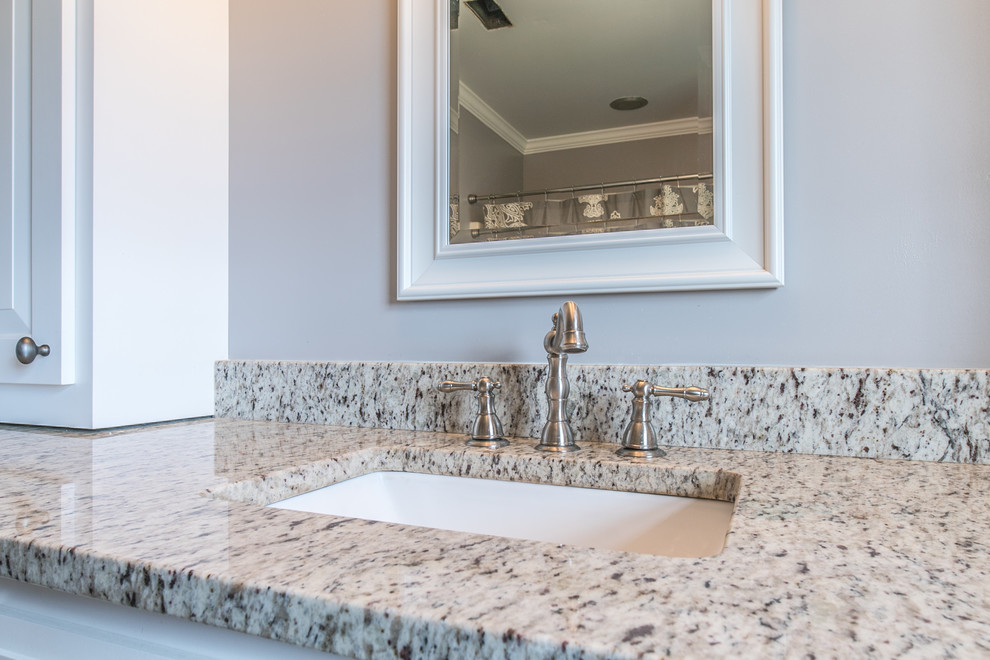 Cette photo montre une petite salle d'eau tendance avec un mur blanc et un plan de toilette en granite.