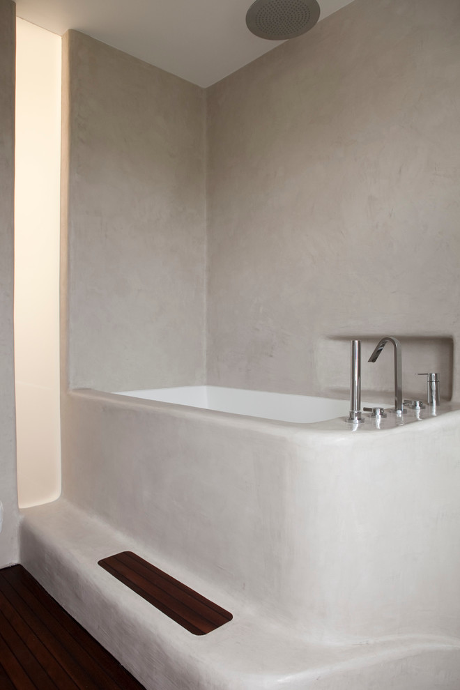 Modern inredning av ett litet en-suite badrum, med ett integrerad handfat, luckor med infälld panel, ett japanskt badkar, en dusch/badkar-kombination, en toalettstol med hel cisternkåpa och mellanmörkt trägolv
