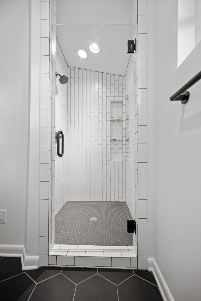 Источник вдохновения для домашнего уюта: маленькая главная ванная комната в стиле ретро с фасадами островного типа, светлыми деревянными фасадами, душем в нише, унитазом-моноблоком, белыми стенами, полом из керамогранита, монолитной раковиной, столешницей из искусственного камня, черным полом, душем с распашными дверями, белой столешницей, нишей, тумбой под одну раковину, напольной тумбой, сводчатым потолком и обоями на стенах для на участке и в саду