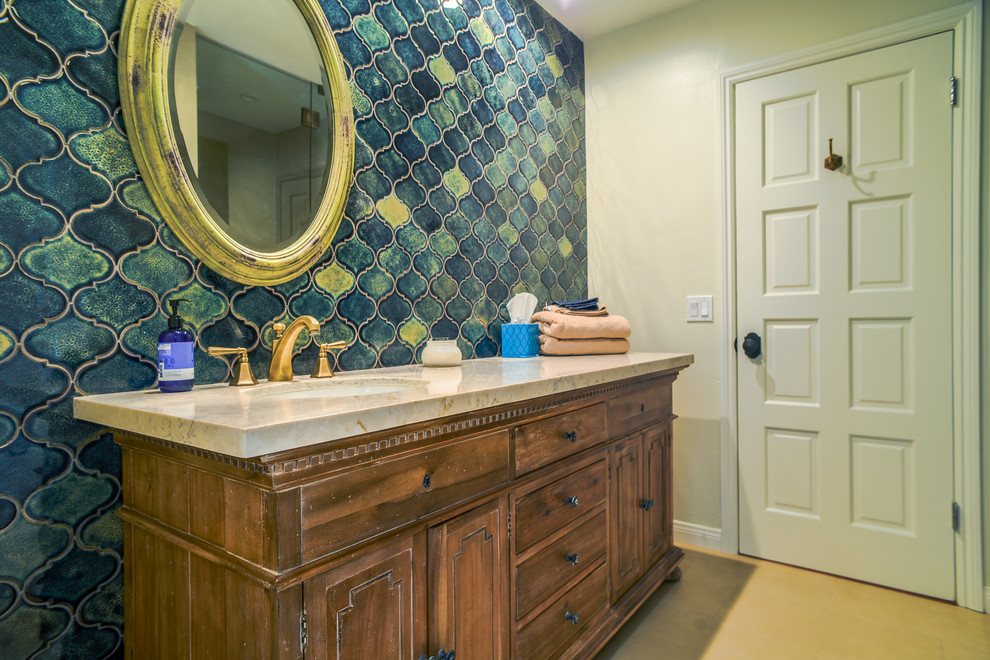 Immagine di una stanza da bagno con doccia country di medie dimensioni con ante con bugna sagomata, ante con finitura invecchiata, piastrelle blu, lavabo da incasso, top in quarzite, piastrelle in gres porcellanato, pavimento in travertino e pavimento beige
