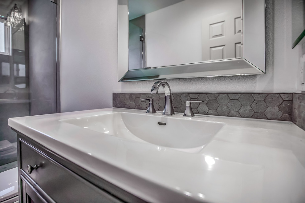Idéer för att renovera ett litet medelhavsstil badrum med dusch, med skåp i shakerstil, grå skåp, en dusch i en alkov, en toalettstol med hel cisternkåpa, grå kakel, porslinskakel, grå väggar, klinkergolv i porslin, ett konsol handfat, bänkskiva i akrylsten, grått golv och dusch med gångjärnsdörr