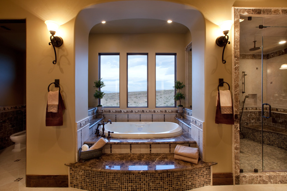 Design ideas for a large mediterranean ensuite bathroom in Las Vegas with a built-in bath, an alcove shower, beige walls, marble flooring, beige floors and a hinged door.