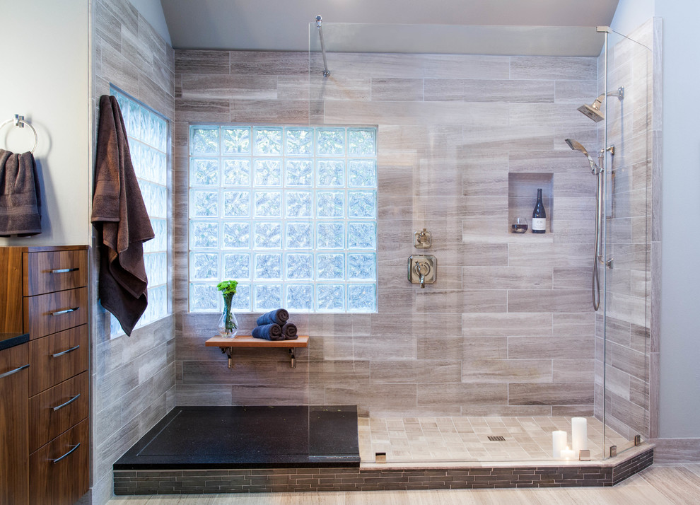 Photo of a contemporary bathroom in Austin with a submerged sink, flat-panel cabinets, brown cabinets, quartz worktops, a walk-in shower, grey tiles and stone tiles.