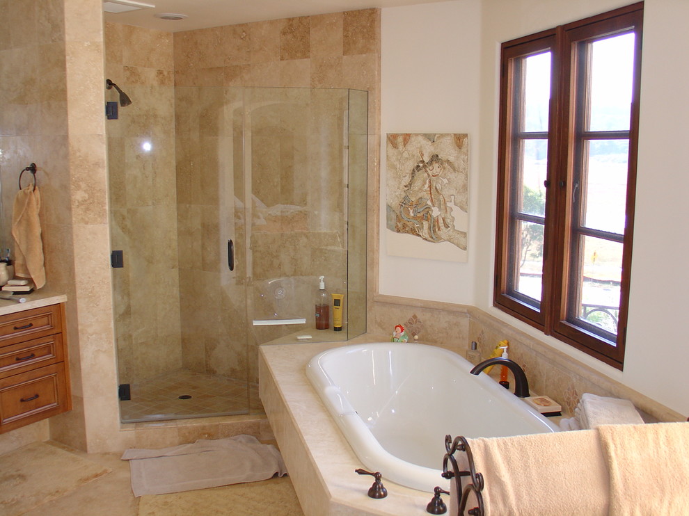 Idée de décoration pour une grande salle de bain principale méditerranéenne en bois brun avec un placard à porte affleurante, une baignoire posée, une douche d'angle, WC à poser, un carrelage beige, du carrelage en travertin, un mur blanc, un sol en travertin, une vasque, un plan de toilette en granite, un sol beige et une cabine de douche à porte battante.