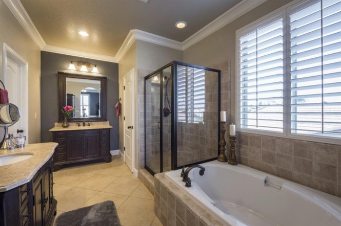 Example of a large trendy master gray tile and ceramic tile ceramic tile and beige floor bathroom design in Other with raised-panel cabinets, dark wood cabinets, an undermount sink, tile countertops, beige walls and a hinged shower door