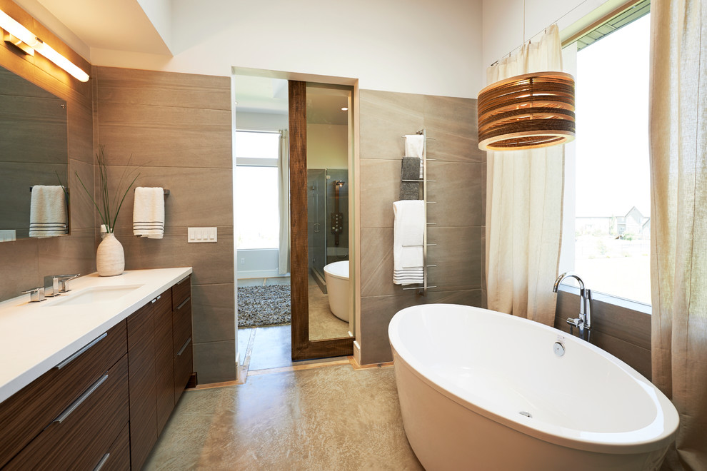 Идея дизайна: ванная комната в современном стиле с врезной раковиной, плоскими фасадами, темными деревянными фасадами, отдельно стоящей ванной и серой плиткой