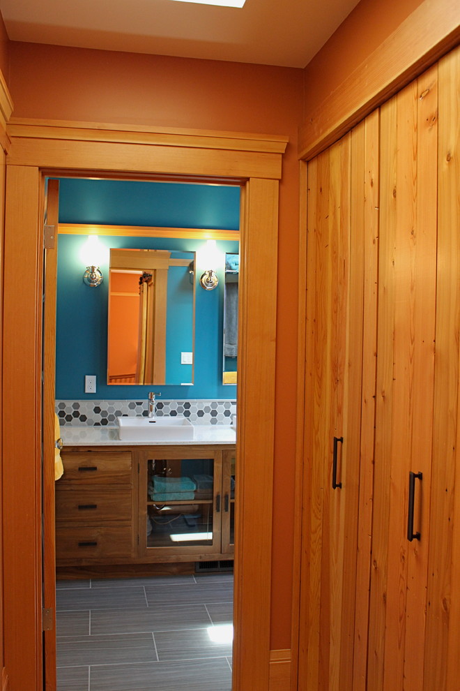 Réalisation d'un sauna design en bois vieilli avec un placard en trompe-l'oeil, un carrelage gris, des carreaux de céramique, un mur bleu, un sol en carrelage de céramique, une vasque et un plan de toilette en verre recyclé.