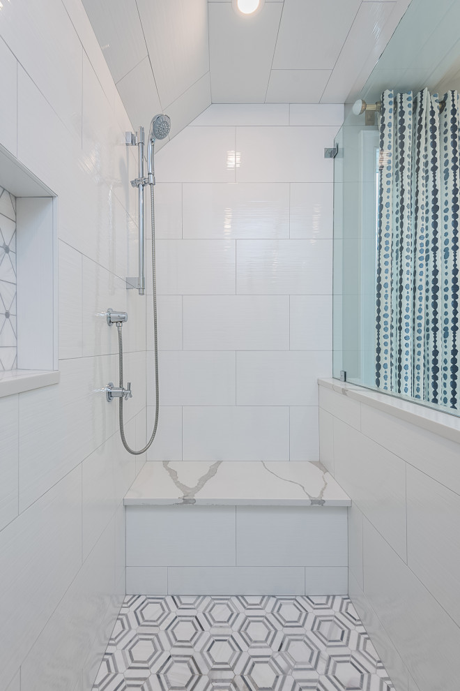 This is an example of a large modern ensuite bathroom in Boston with recessed-panel cabinets, blue cabinets, a freestanding bath, a built-in shower, a one-piece toilet, grey tiles, ceramic tiles, grey walls, ceramic flooring, a submerged sink, engineered stone worktops, grey floors, a hinged door, white worktops, a shower bench, double sinks and a built in vanity unit.