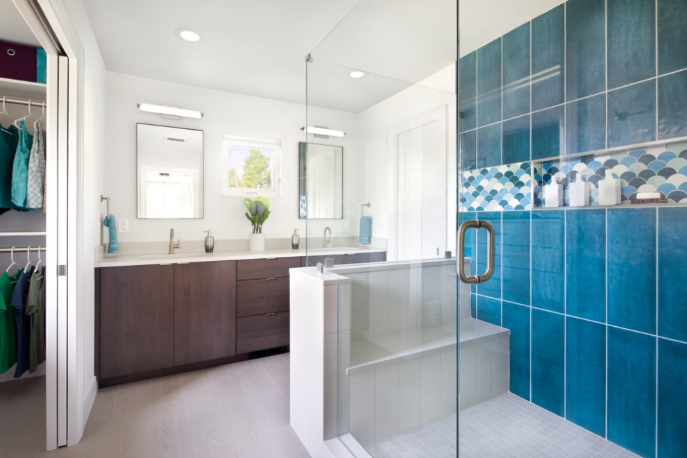 Example of a mid-sized trendy master blue tile and ceramic tile wet room design in Denver with flat-panel cabinets, dark wood cabinets, a one-piece toilet, white walls, a drop-in sink, granite countertops, a hinged shower door and white countertops
