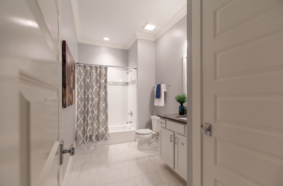 Example of a mid-sized transitional white tile and subway tile marble floor bathroom design in Raleigh with shaker cabinets, white cabinets, gray walls and an undermount sink