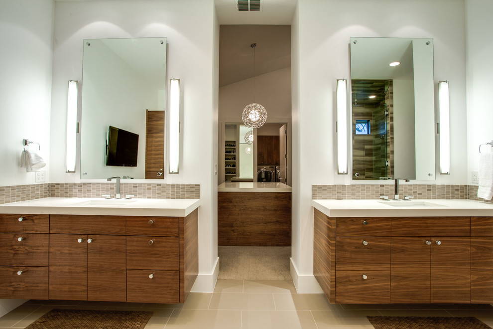 Cette photo montre une salle de bain tendance en bois brun avec un lavabo encastré, un placard à porte plane, un carrelage beige et mosaïque.