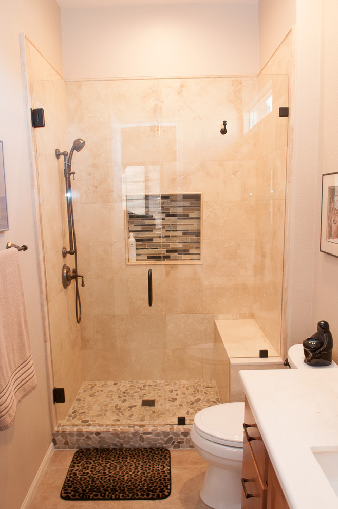 Bild på ett litet orientaliskt badrum med dusch, med släta luckor, skåp i ljust trä, en dusch i en alkov, en toalettstol med separat cisternkåpa, beige kakel, porslinskakel, beige väggar, klinkergolv i porslin, ett undermonterad handfat, bänkskiva i kvarts, beiget golv och dusch med gångjärnsdörr