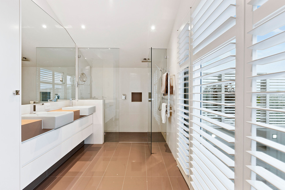 メルボルンにある中くらいなコンテンポラリースタイルのおしゃれな浴室 (オーバーカウンターシンク、フラットパネル扉のキャビネット、白いキャビネット、アルコーブ型シャワー、白いタイル、白い壁) の写真
