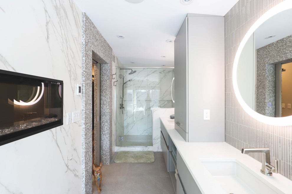 На фото: главная ванная комната в стиле неоклассика (современная классика) с плоскими фасадами, серыми фасадами, отдельно стоящей ванной, душем в нише, унитазом-моноблоком, белыми стенами, полом из керамической плитки, врезной раковиной, столешницей из кварцита, серым полом, душем с распашными дверями, белой столешницей, нишей, тумбой под две раковины и подвесной тумбой