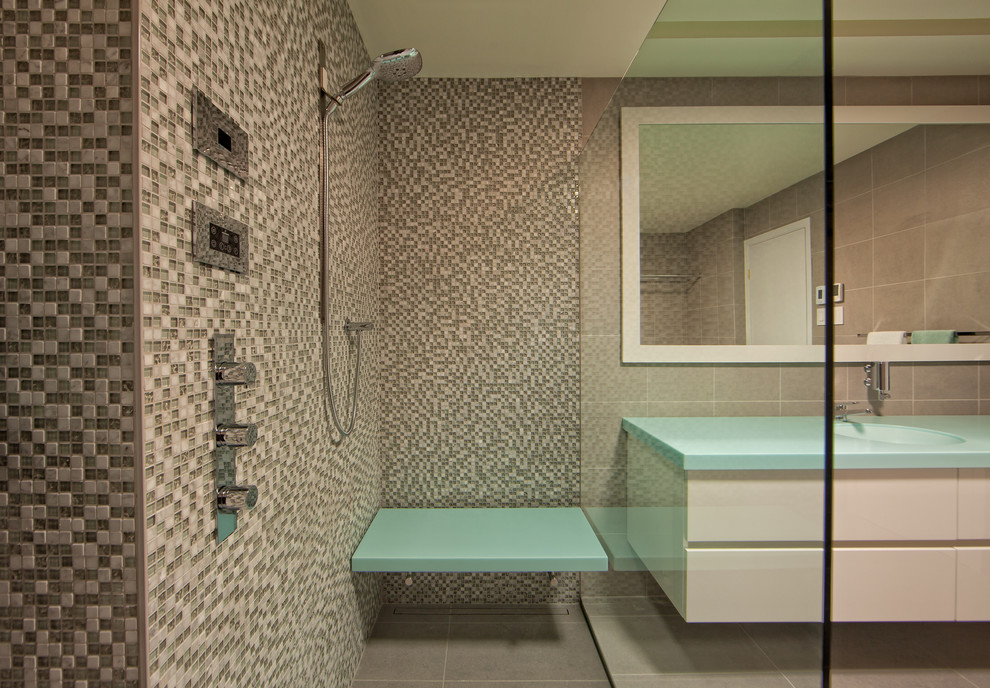Ispirazione per una stanza da bagno padronale minimal di medie dimensioni con lavabo integrato, ante lisce, ante bianche, doccia aperta, WC sospeso, piastrelle di vetro e pavimento in gres porcellanato