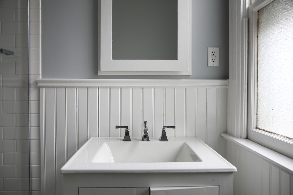 Свежая идея для дизайна: ванная комната среднего размера в викторианском стиле с белыми фасадами, угловым душем, раздельным унитазом, белой плиткой, керамической плиткой, серыми стенами, полом из керамической плитки, душевой кабиной, монолитной раковиной, разноцветным полом, душем с распашными дверями и белой столешницей - отличное фото интерьера