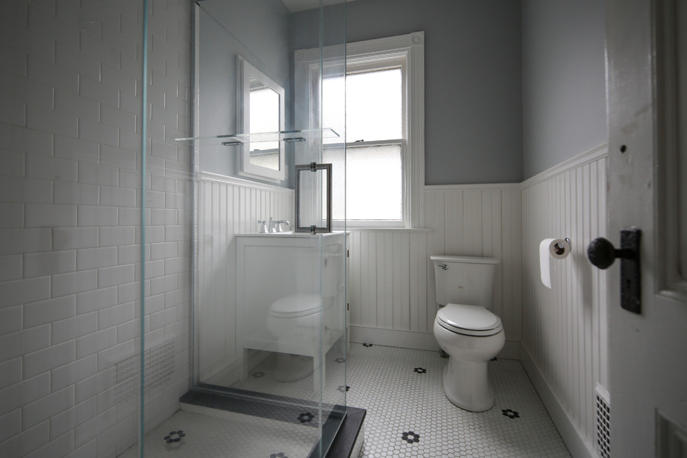 Стильный дизайн: ванная комната среднего размера в викторианском стиле с белыми фасадами, угловым душем, раздельным унитазом, белой плиткой, керамической плиткой, серыми стенами, полом из керамической плитки, душевой кабиной, монолитной раковиной, разноцветным полом, душем с распашными дверями и белой столешницей - последний тренд