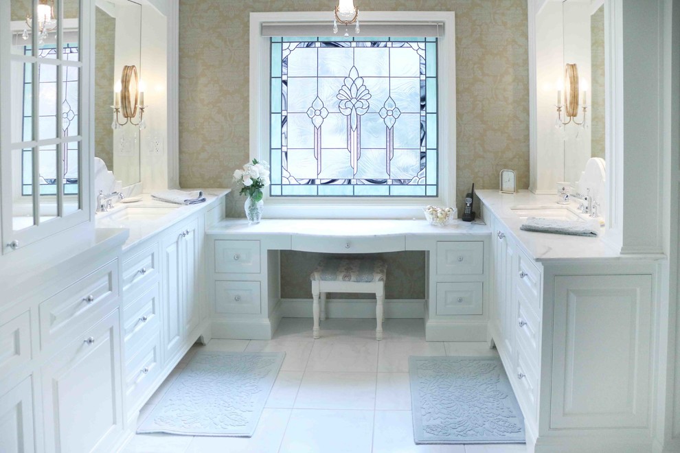 Foto de cuarto de baño tradicional con lavabo bajoencimera, armarios con paneles con relieve, puertas de armario blancas y baldosas y/o azulejos blancos