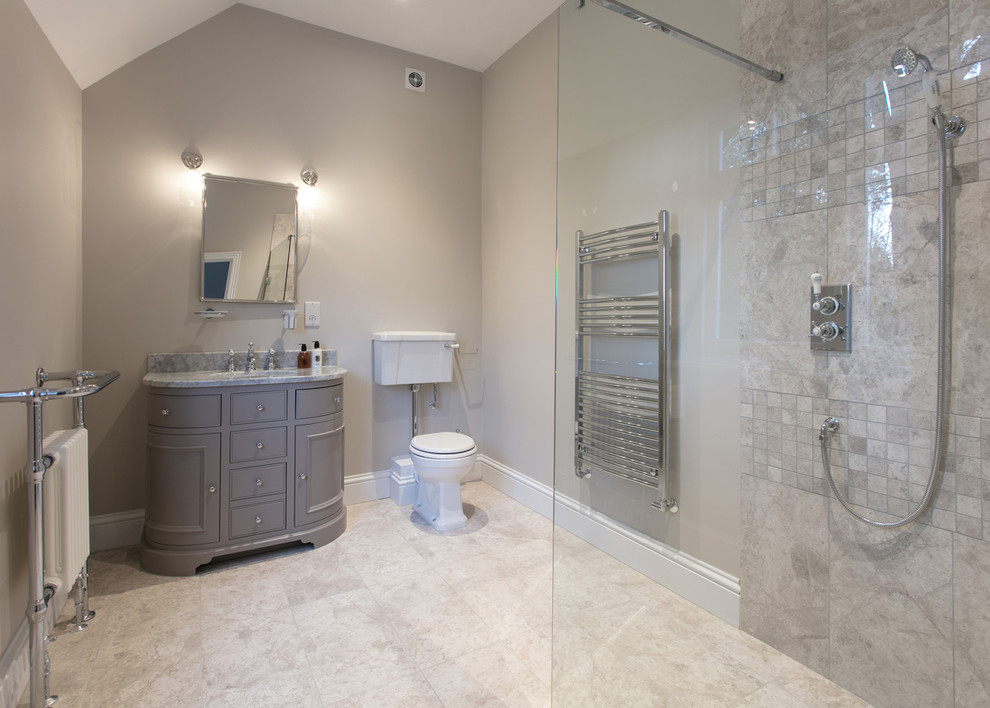 Inredning av ett klassiskt mellanstort grå grått en-suite badrum, med skåp i shakerstil, grå skåp, en öppen dusch, en toalettstol med separat cisternkåpa, grå kakel, kakelplattor, grå väggar, kalkstensgolv, ett nedsänkt handfat, marmorbänkskiva, grått golv och med dusch som är öppen