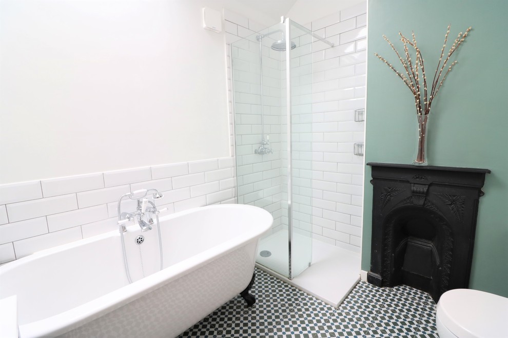 This is an example of a medium sized traditional family bathroom in Cambridgeshire with shaker cabinets, blue cabinets, a claw-foot bath, a walk-in shower, white tiles, ceramic tiles, white walls, cement flooring, a built-in sink, quartz worktops, multi-coloured floors and white worktops.