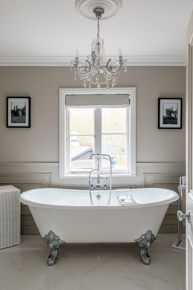На фото: главная, серо-белая ванная комната среднего размера в классическом стиле с ванной на ножках, серыми стенами, тумбой под одну раковину, напольной тумбой, серым полом и панелями на стенах