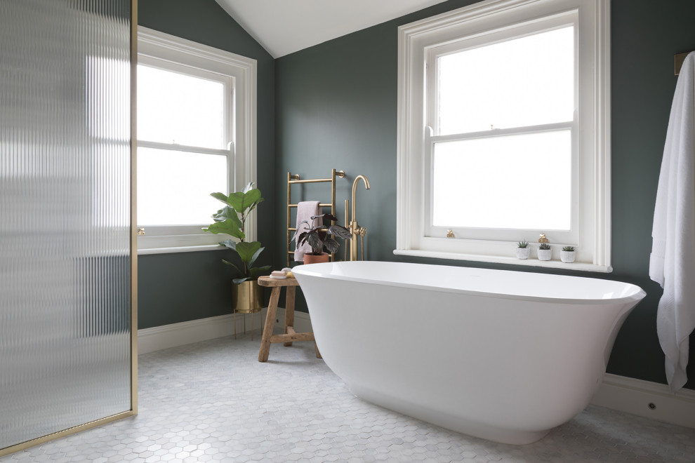 Example of a mid-sized eclectic master marble floor, double-sink and vaulted ceiling bathroom design in Kent with a wall-mount toilet, green walls, solid surface countertops, white countertops, a niche and a floating vanity