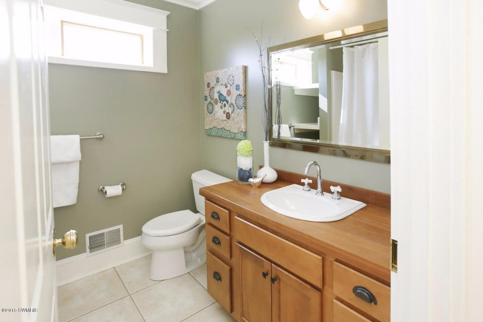 Mid-sized ornate kids' beige tile and cement tile dark wood floor tub/shower combo photo in Grand Rapids with a drop-in sink, flat-panel cabinets, medium tone wood cabinets, wood countertops, a one-piece toilet and green walls