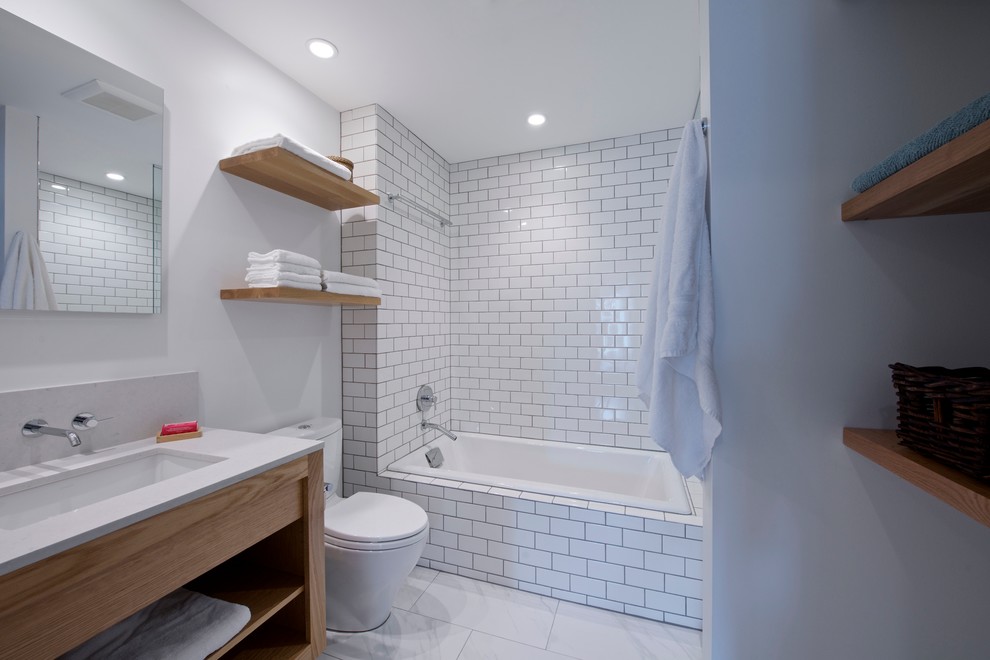 Inspiration för mellanstora moderna en-suite badrum, med ett undermonterad handfat, öppna hyllor, skåp i ljust trä, ett platsbyggt badkar, en öppen dusch, en toalettstol med separat cisternkåpa, vit kakel, tunnelbanekakel, vita väggar och marmorgolv