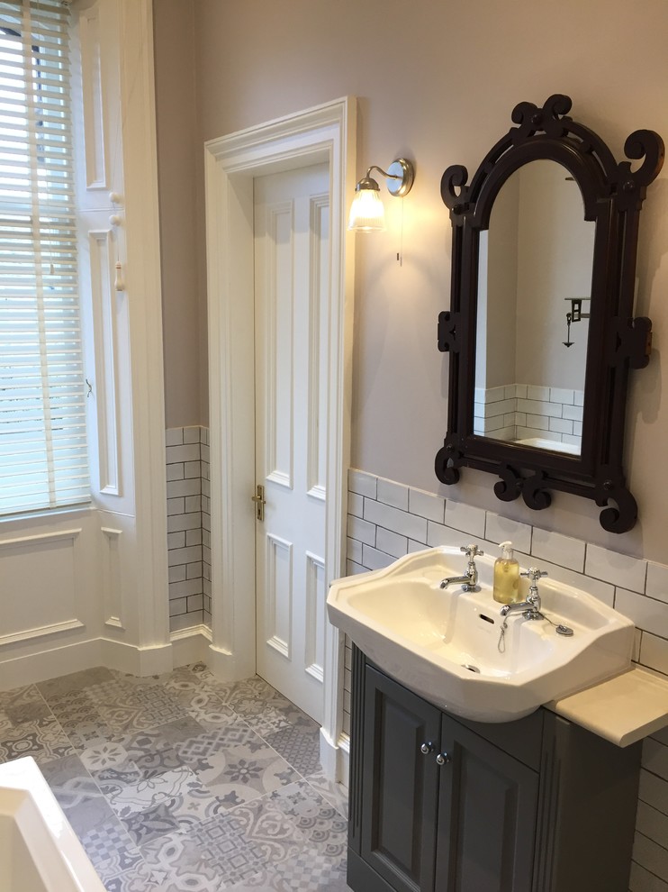 Design ideas for a large victorian ensuite bathroom in Cornwall with shaker cabinets, grey cabinets, a built-in bath, a walk-in shower, a two-piece toilet, white tiles, ceramic tiles, beige walls, porcelain flooring, a built-in sink and laminate worktops.