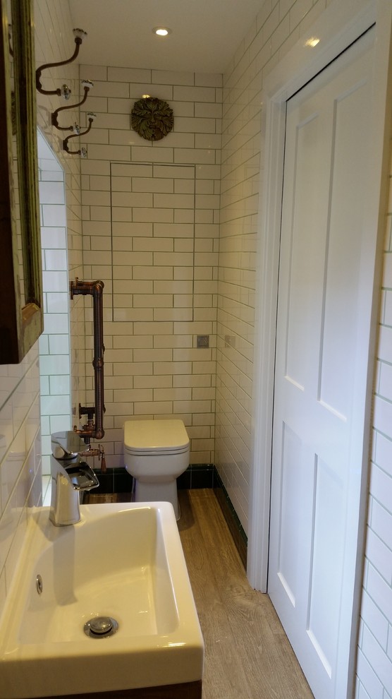 ロンドンにあるラグジュアリーな小さなインダストリアルスタイルのおしゃれなバスルーム (浴槽なし) (フラットパネル扉のキャビネット、淡色木目調キャビネット、洗い場付きシャワー、一体型トイレ	、白いタイル、セラミックタイル、白い壁、セラミックタイルの床、一体型シンク、マルチカラーの床、オープンシャワー) の写真