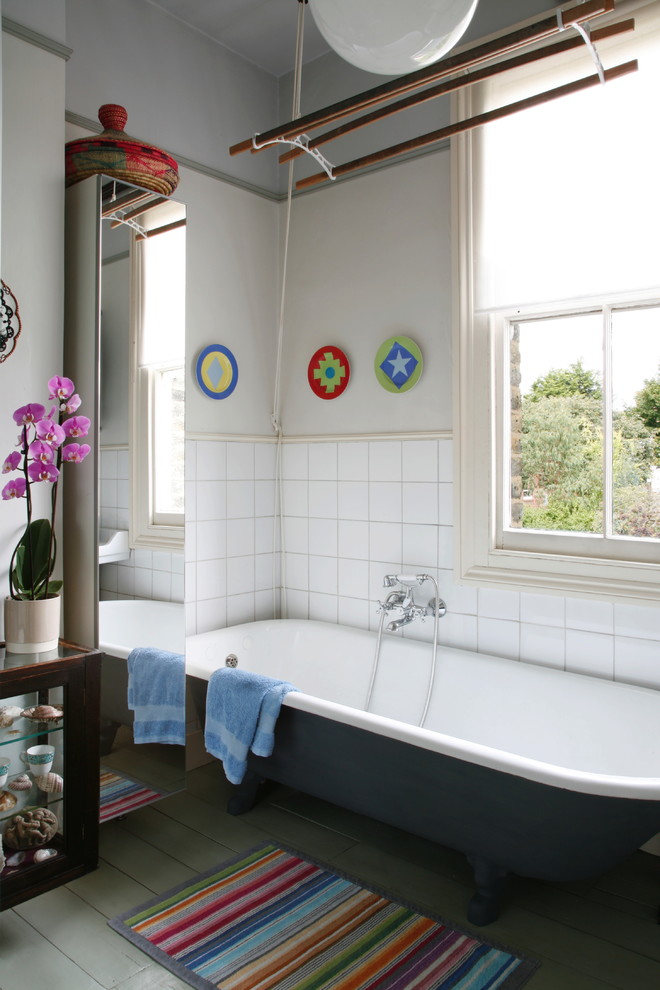 Photo of an eclectic bathroom in London with glass-front cabinets.