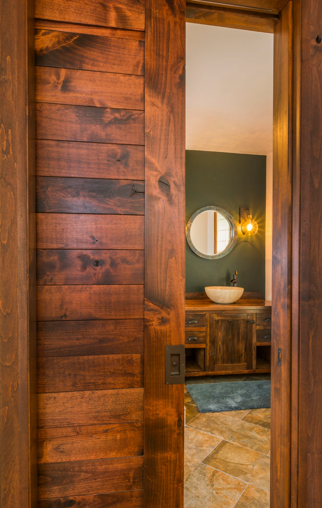 Kleines Stilmix Badezimmer mit Aufsatzwaschbecken, flächenbündigen Schrankfronten, dunklen Holzschränken, Waschtisch aus Holz, beigen Fliesen, grüner Wandfarbe und Keramikboden in Sonstige