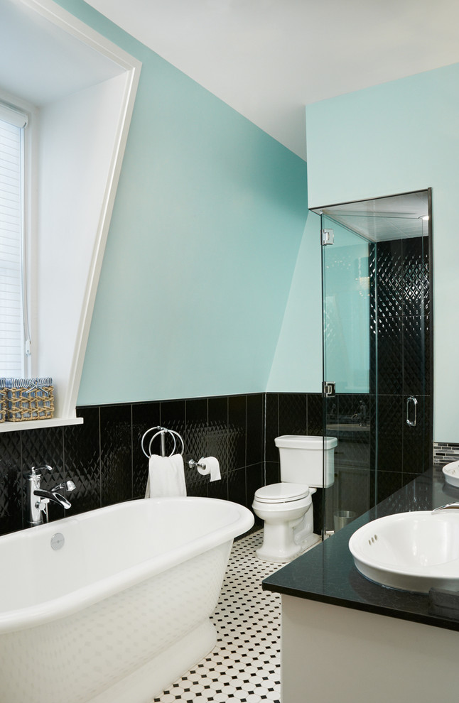 Immagine di una stanza da bagno vittoriana con vasca freestanding e piastrelle nere