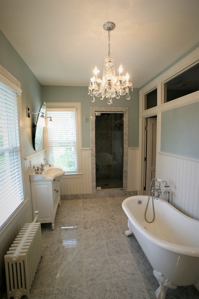 Idéer för att renovera ett mellanstort vintage vit vitt en-suite badrum, med luckor med upphöjd panel, vita skåp, ett badkar med tassar, en toalettstol med separat cisternkåpa, vit kakel, stenkakel, vita väggar, marmorgolv, ett integrerad handfat, bänkskiva i akrylsten, grått golv, en dusch i en alkov och dusch med gångjärnsdörr