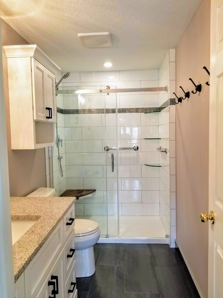 Idéer för ett mellanstort klassiskt badrum med dusch, med luckor med infälld panel, vita skåp, en dusch i en alkov, en toalettstol med hel cisternkåpa, vit kakel, tunnelbanekakel, lila väggar, klinkergolv i porslin, bänkskiva i kvartsit, grått golv och dusch med skjutdörr