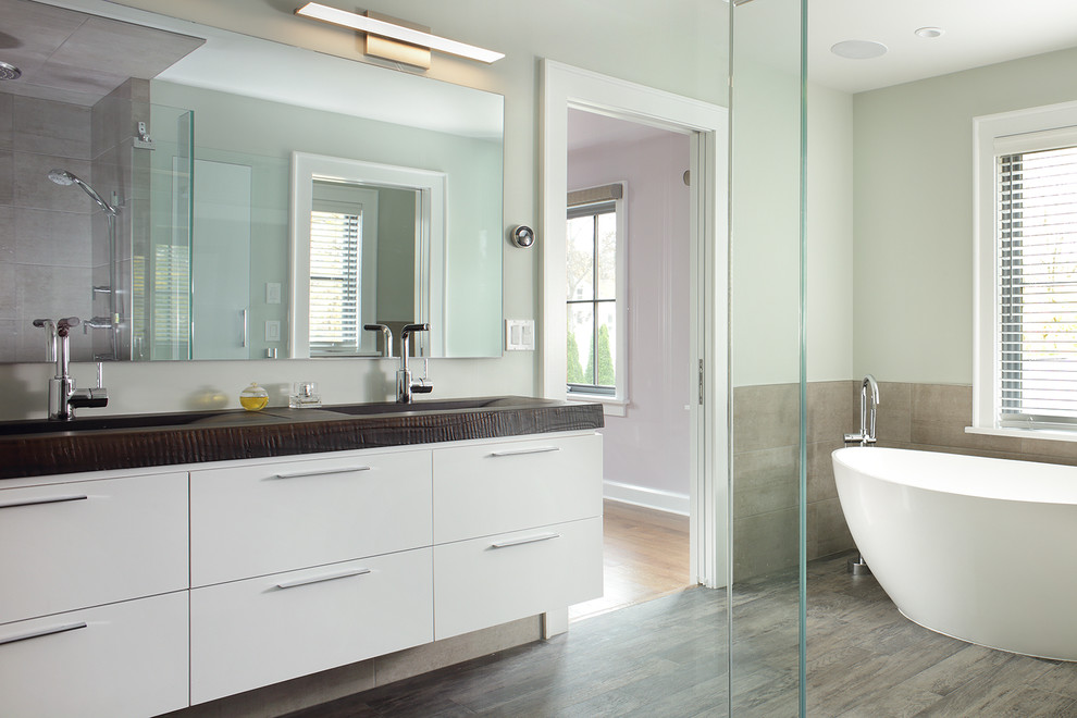 Cette image montre une salle de bain principale design de taille moyenne avec un placard à porte plane, des portes de placard blanches, un mur beige et parquet clair.