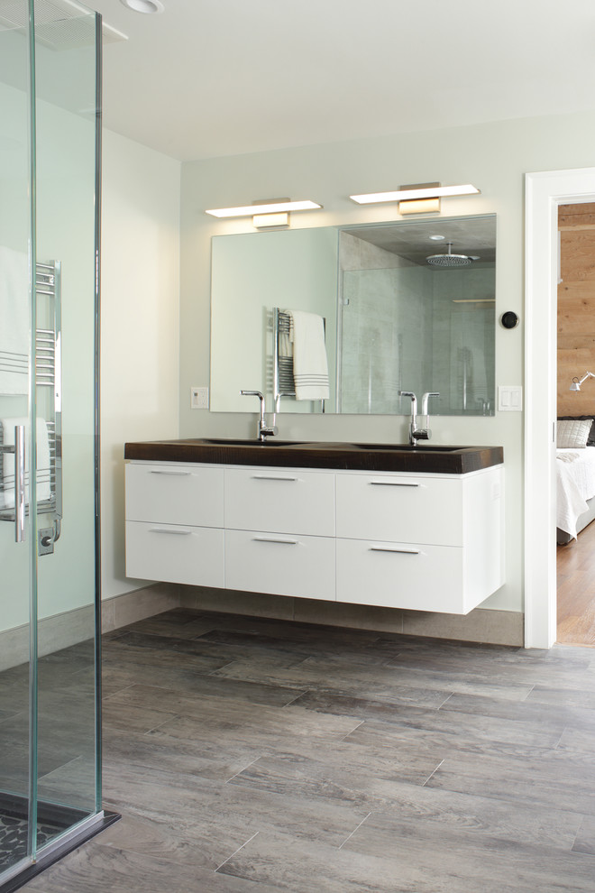 Cette photo montre une salle de bain principale tendance de taille moyenne avec un placard à porte plane, des portes de placard blanches, un mur beige et parquet clair.