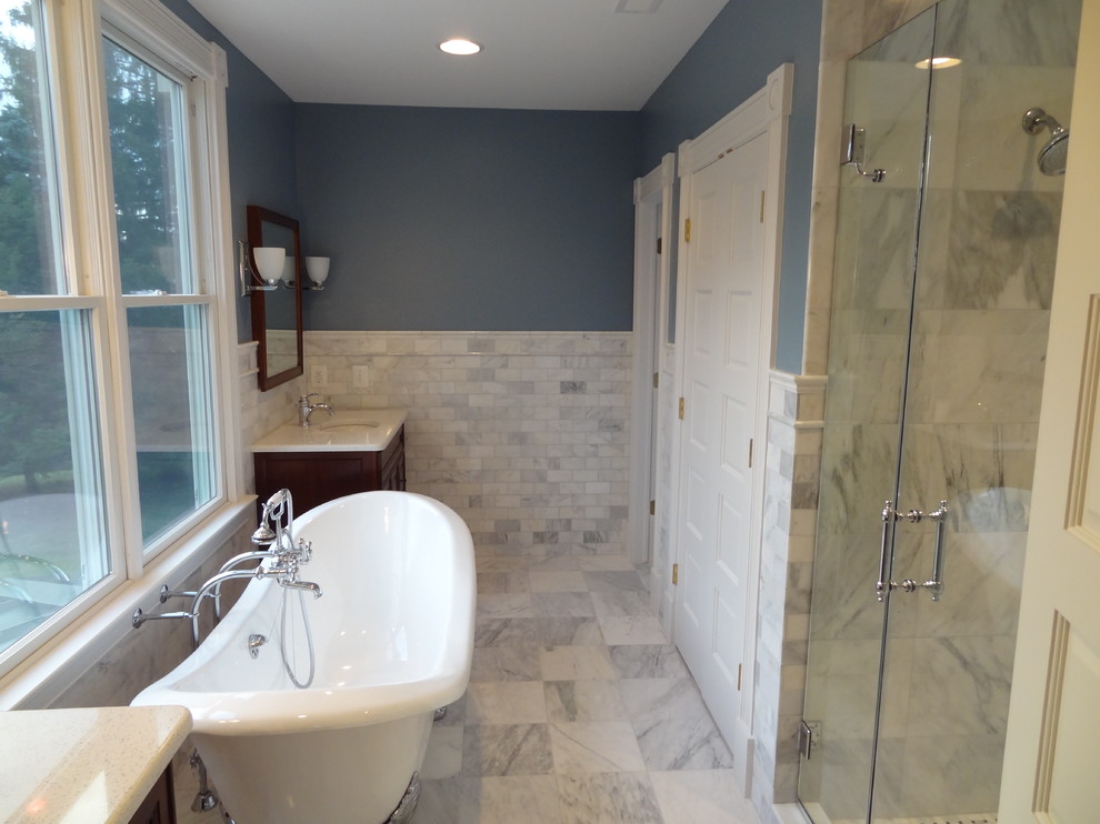 Photo of a medium sized country ensuite bathroom in Baltimore with shaker cabinets, dark wood cabinets, a freestanding bath, an alcove shower, black and white tiles, grey tiles, stone tiles, blue walls, marble flooring and a submerged sink.