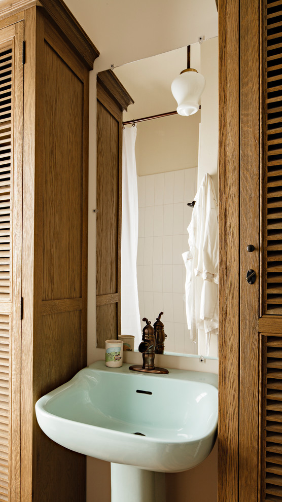 Пример оригинального дизайна: маленькая ванная комната в викторианском стиле с фасадами с филенкой типа жалюзи, раковиной с пьедесталом, фасадами цвета дерева среднего тона, душем в нише, белой плиткой, керамической плиткой, белыми стенами, паркетным полом среднего тона, душевой кабиной, коричневым полом и шторкой для ванной для на участке и в саду