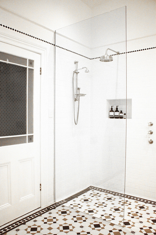 Пример оригинального дизайна: маленькая главная ванная комната в викторианском стиле с фасадами с выступающей филенкой, белыми фасадами, отдельно стоящей ванной, открытым душем, унитазом-моноблоком, белой плиткой, керамической плиткой, белыми стенами, полом из мозаичной плитки, настольной раковиной, столешницей из искусственного кварца, разноцветным полом и открытым душем для на участке и в саду