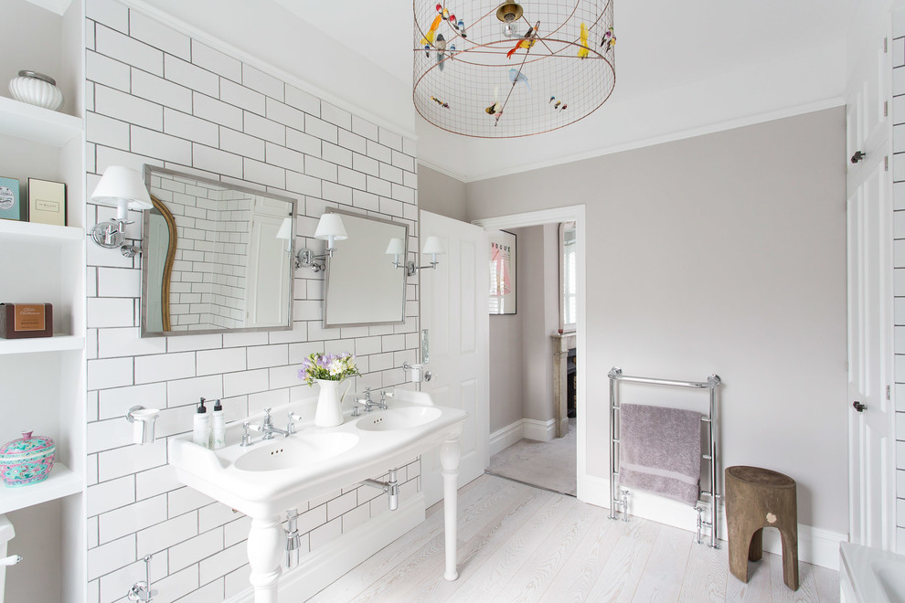 Inspiration for a contemporary ensuite bathroom in London with open cabinets, white cabinets, beige walls, a console sink and light hardwood flooring.